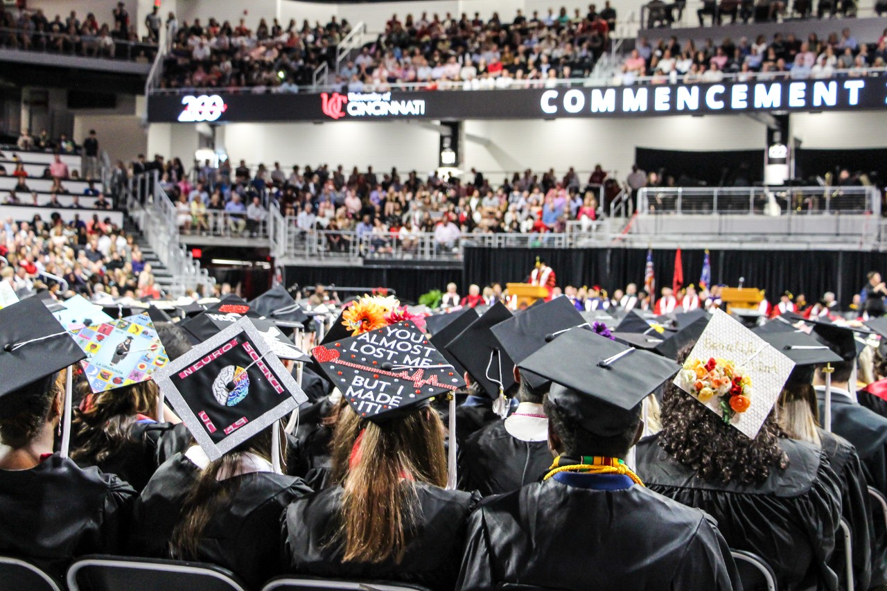 UC Commencement Ceremony, students in their caps and gowns listening to the presenter